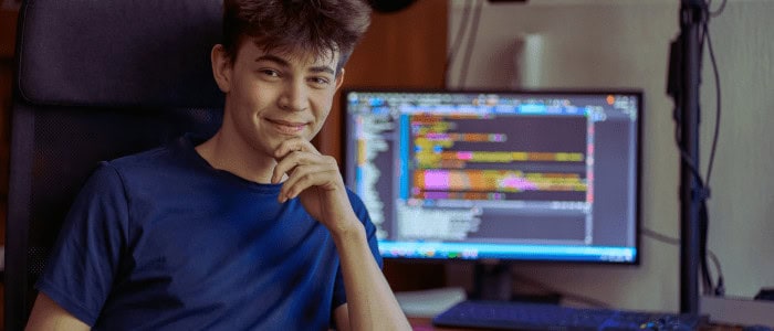 Typický ajťák je introvert, za běžné výdaje domácnosti utratí 1/4 příjmu 1 Mladý muž pracující na počítači s kódem, IT služby, kybernetická bezpečnost.