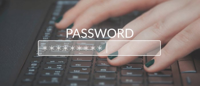 Ruka zadávající heslo na klávesnici, zobrazeno heslo s hvězdičkami.