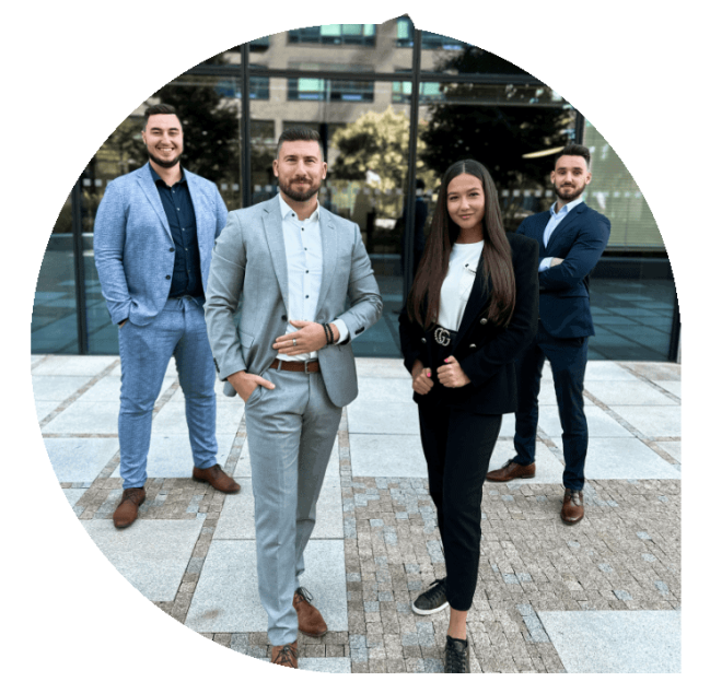 Skupina čtyř profesionálů v obleku na venkovní schůzce.